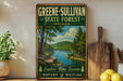 A vintage-style sign for Greene-Sullivan State Forest in Indiana, featuring a scenic landscape with a river and trees.
