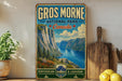 A vintage-style sign for Gros Morne National Park, Canada, featuring a scenic mountain landscape with a lake and pine trees.