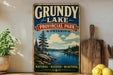 A vintage-style sign for Grubby Lake Provincial Park, Ontario, featuring a scenic landscape with a lake, pine trees, and mountains.
