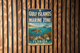 A vintage metal sign for the Gulf Islands National Seashore Marine Zone in Florida, featuring an illustration of marine life and the text "Gulf Islands National Seashore Marine Zone" and "FLORIDA".