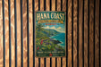 A vintage-style metal sign for the Hana Coast, Hawaii, featuring a tropical landscape with palm trees, mountains, and the ocean.