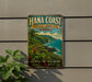 A vintage-style metal sign for the Hana Coast, Hawaii, featuring a tropical landscape with palm trees, mountains, and the ocean.