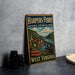 A vintage-style metal sign for the Harpers Ferry National Historical Park in West Virginia, featuring an illustration of a town and a river.