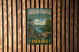 A vintage metal sign for Harrison-Crawford State Forest, featuring a scenic landscape with a river and mountains.
