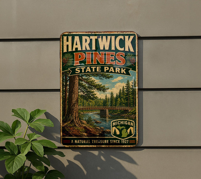 A vintage metal sign for Hartwick Pines State Park, featuring a scenic image of a forest and a bridge.