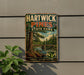 A vintage metal sign for Hartwick Pines State Park, featuring a scenic image of a forest and a bridge.