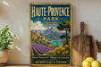 A vintage metal sign for Haute-Provence Park in France, featuring a scenic landscape with mountains, fields, and a river.