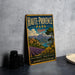 A vintage metal sign for Haute-Provence Park, France, featuring a scenic landscape with mountains, villages, and lavender fields.