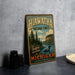 A vintage-style metal sign for the Hawatha National Forest in Michigan, featuring a scenic illustration of a lake surrounded by pine trees and mountains.