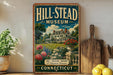 A vintage-style poster for the Hill-Stead Museum in Connecticut, featuring a large house surrounded by a garden and flowers.