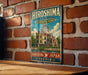 A vintage-style metal sign displaying the name "Hiroshima Peace Memorial Genbaku Dome" and the location "Hiroshima, Japan" is hanging on a brick wall.