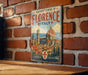 A vintage-style metal sign with the text "HISTORIC CENTRE OF FLORENCE ITALY" and an illustration of the Florence Cathedral, which is a historic center of Florence, Italy.