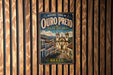 A vintage metal sign with the text "Historic Town of Oururo Preto" and an illustration of a historic town in Brazil.