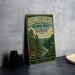 A vintage-style metal sign for the Homochito National Forest in Mississippi, featuring a scenic illustration of a forest and a river.