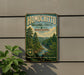 A vintage-style metal sign for the Homochito National Forest in Mississippi, featuring a scenic image of a forest and a river.