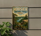 A vintage-style sign for Hoosier National Forest, Indiana, featuring a scenic landscape with a lake and mountains.