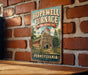 A vintage-style metal sign for the Hopewell Furnace National Historic Site in Pennsylvania, featuring an illustration of a stone building with a chimney.