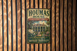 A vintage-style metal sign for Houmas House, a landmark in Louisiana, is displayed on a wooden wall.