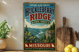 A vintage-style metal sign for Huckleberry Ridge State Forest in Missouri, featuring a scenic mountain landscape with a river and pine trees.