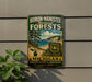 A vintage metal sign for Huron-Manistee National Forests in Michigan, featuring a scenic landscape with pine trees, a lake, and mountains.