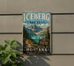 A vintage-style sign for the Iceberg Lake Trail in Glacier National Park, Montana, featuring a scenic mountain landscape with a lake in the background.