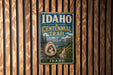 A vintage metal sign for the Idaho Centennial Trail, featuring a mountain landscape and the text "Idaho Centennial Trail" prominently displayed.