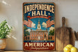 A vintage-style metal sign with the text "Independence Hall" and "Birthplace of American Independence" hangs on a wall, surrounded by kitchen utensils and a potted plant.