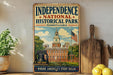 a vintage-style metal sign for Independence National Historical Park in Pennsylvania, with a bell tower and American flag in the background.