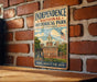A vintage metal sign for Independence National Historical Park in Pennsylvania, featuring an illustration of the Independence Building and an American flag.