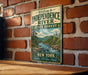 A vintage metal sign with the text "Welcome to Independence River State Forest New York Explore Discover Enjoy" is displayed on a brick wall.