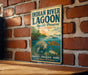 A vintage-style sign for the Indian River Lagoon Aquatic Preserve in Florida, featuring an illustration of a manatee and a turtle in a serene natural setting.