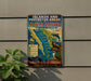 A vintage metal sign on a wall, featuring a map of the Gulf of California and various marine life, including a dolphin and a seal.