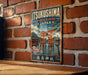 A vintage-style metal sign with the text "ItsukUSHIMA SHINTO SHRINE JAPAN" and an illustration of a traditional Japanese torii gate, which is a famous Shinto shrine located in ItsukUSHIMA, Japan.