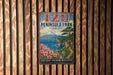 A vintage metal sign for Izu Peninsula Park in Japan, featuring a scenic landscape with a mountain, ocean, and flowers.