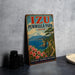 A vintage-style sign for Izu Peninsula Park in Japan, featuring a scenic landscape with a mountain, ocean, and flowers.