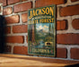 A vintage metal sign for the Jackson State Forest in California, featuring a scenic illustration of a forest and mountains.