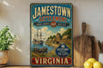 A vintage-style sign for Jamestown Settlement, Virginia, featuring a ship, people, and a coastal scene.