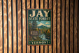 A vintage metal sign for the Jay State Forest in Vermont, featuring a scenic image of the forest and mountains.