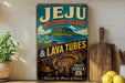 A vintage-style sign advertising Jeju Volcanic Island, featuring a scenic illustration of the island, lava tubes, and a tunnel leading to a mountain.