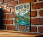 A vintage-style metal sign with the text "JUZHAIACOU VALLEY SCenic and Historic Interest Area" and "CHINA" printed on it, hanging on a brick wall.
