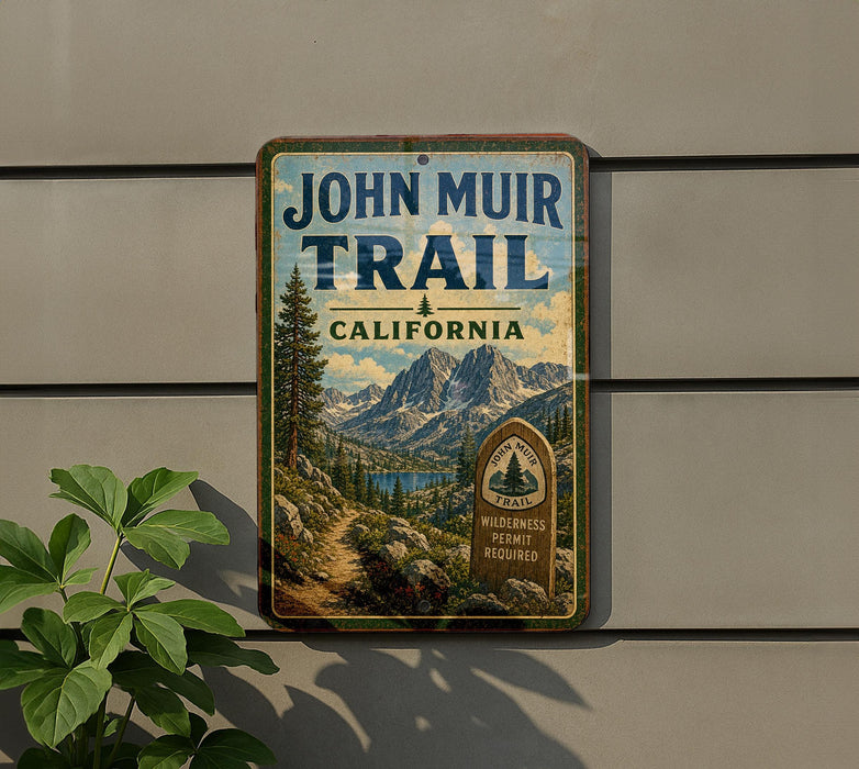 A vintage-style metal sign for the John Muir Trail in California, featuring a scenic mountain landscape and a trail marker.