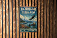 A metal sign for the Kachemak Bay National Estuarine Research Reserve in Alaska, featuring an eagle, a seal, and a boat on the water.