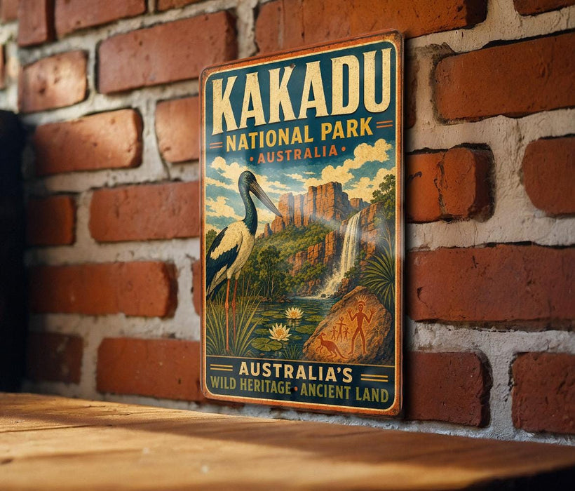 A vintage-style metal sign for Kakadu National Park in Australia, featuring an illustration of a bird and a waterfall.