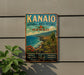 A vintage-style metal sign with the text "KANAIO NATURAL AREA RESERVE HAWAII" and a tropical landscape depicting a beach, mountains, and palm trees.