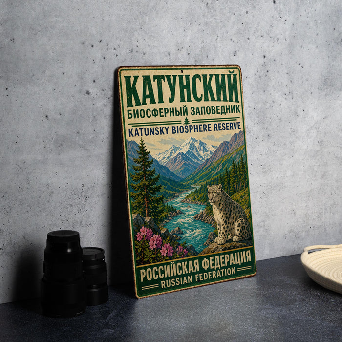 A vintage metal sign with Russian text and an illustration of a mountain landscape, featuring a leopard.