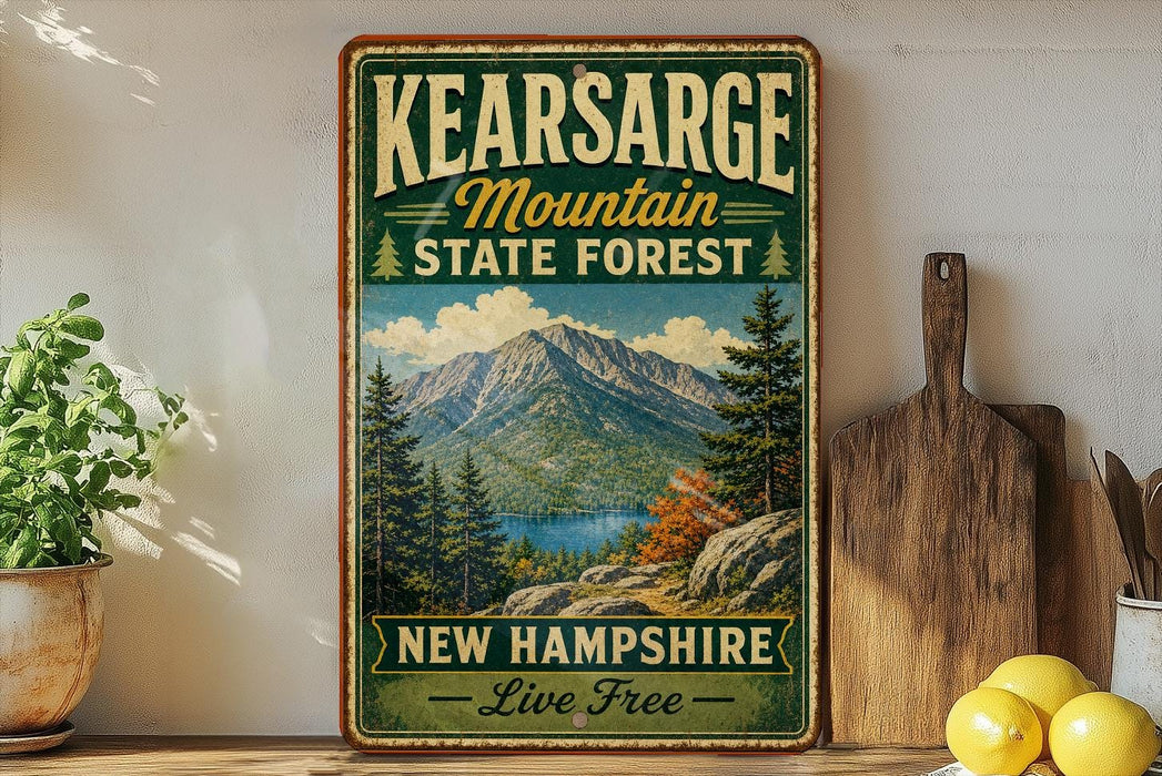 A vintage-style sign for the state forest in New Hampshire, featuring a mountain landscape and the text "Kearsarge Mountain State Forest New Hampshire Live Free".