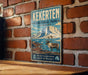 A vintage-style metal sign for Kekerten Territorial Park, featuring an illustration of a reindeer in a mountainous landscape.