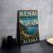 A vintage metal sign for Kenai Mountains Turn Again Arm National Heritage Area in Alaska, featuring a scenic mountain landscape with a winding road and a small boat on the water.