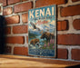 A vintage-style sign for the Kenai National Wildlife Refuge in Alaska, featuring an illustration of a moose, bear, and eagle in a natural setting.