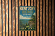 A vintage metal sign for Kentucky Ridge State Forest, featuring a scenic landscape with mountains, trees, and a cliff overlooking the forest.
